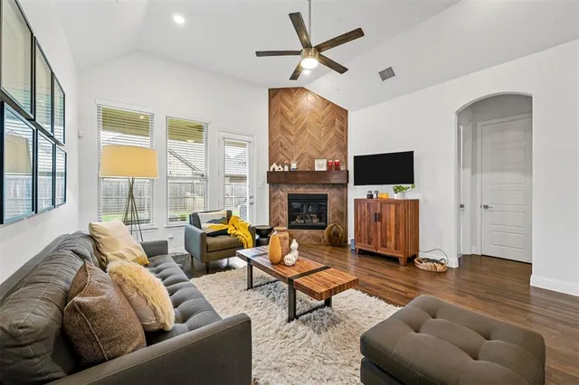 a living room with furniture a fireplace and a flat screen tv