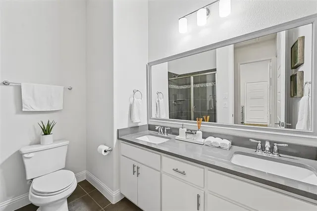 a bathroom with a granite countertop toilet sink and mirror