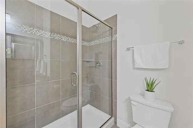 a bath room with a shower and a toilet