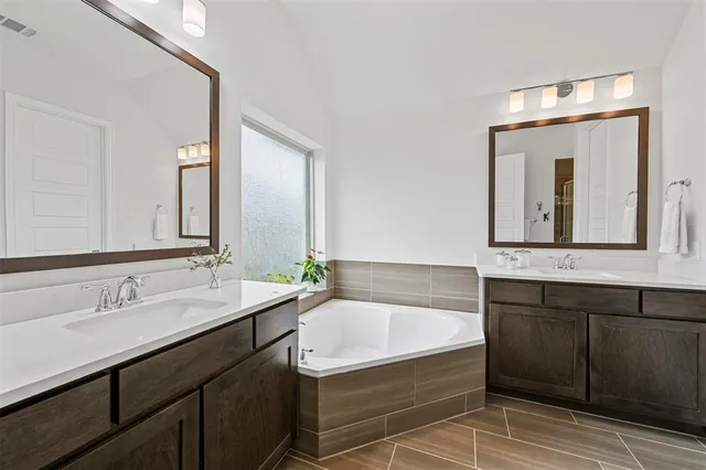 a bathroom with a tub sink and mirror