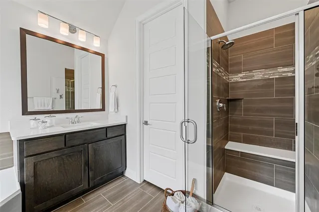 a bathroom with a shower sink and mirror