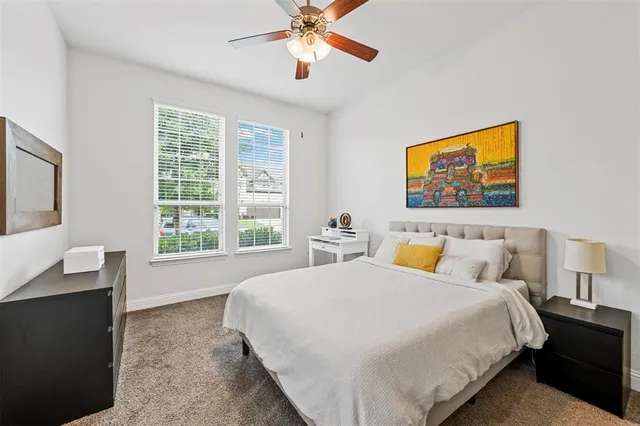 a spacious bedroom with a bed and a chandelier