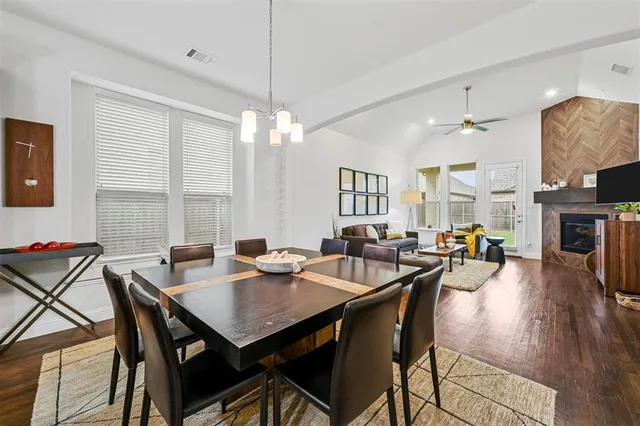 a view of a dining room with furniture a chandelier and wooden floor