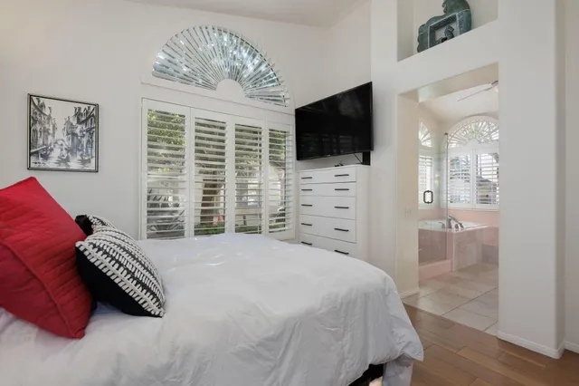 a spacious bathroom with double vanity a mirror a bathtub and a window