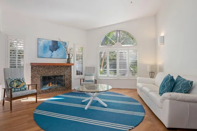 a living room with furniture a fireplace and wooden floor