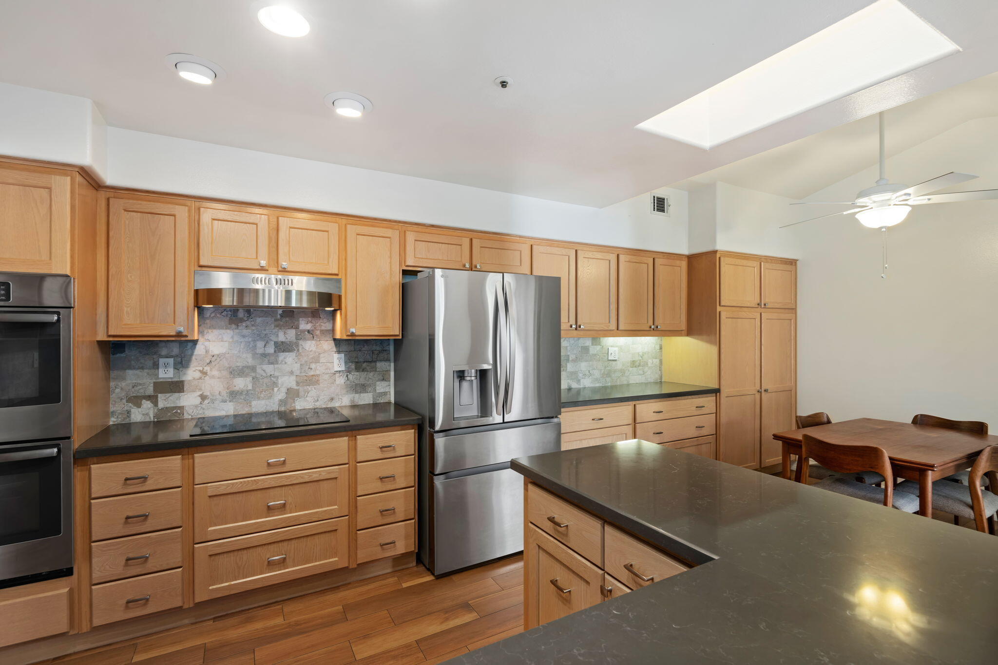 1260 Cravens Lane, Unit 2 Carpinteria, CA 93013 - Photo 8 of 23 a kitchen with granite countertop stainless steel appliances a refrigerator cabinets and wooden floor