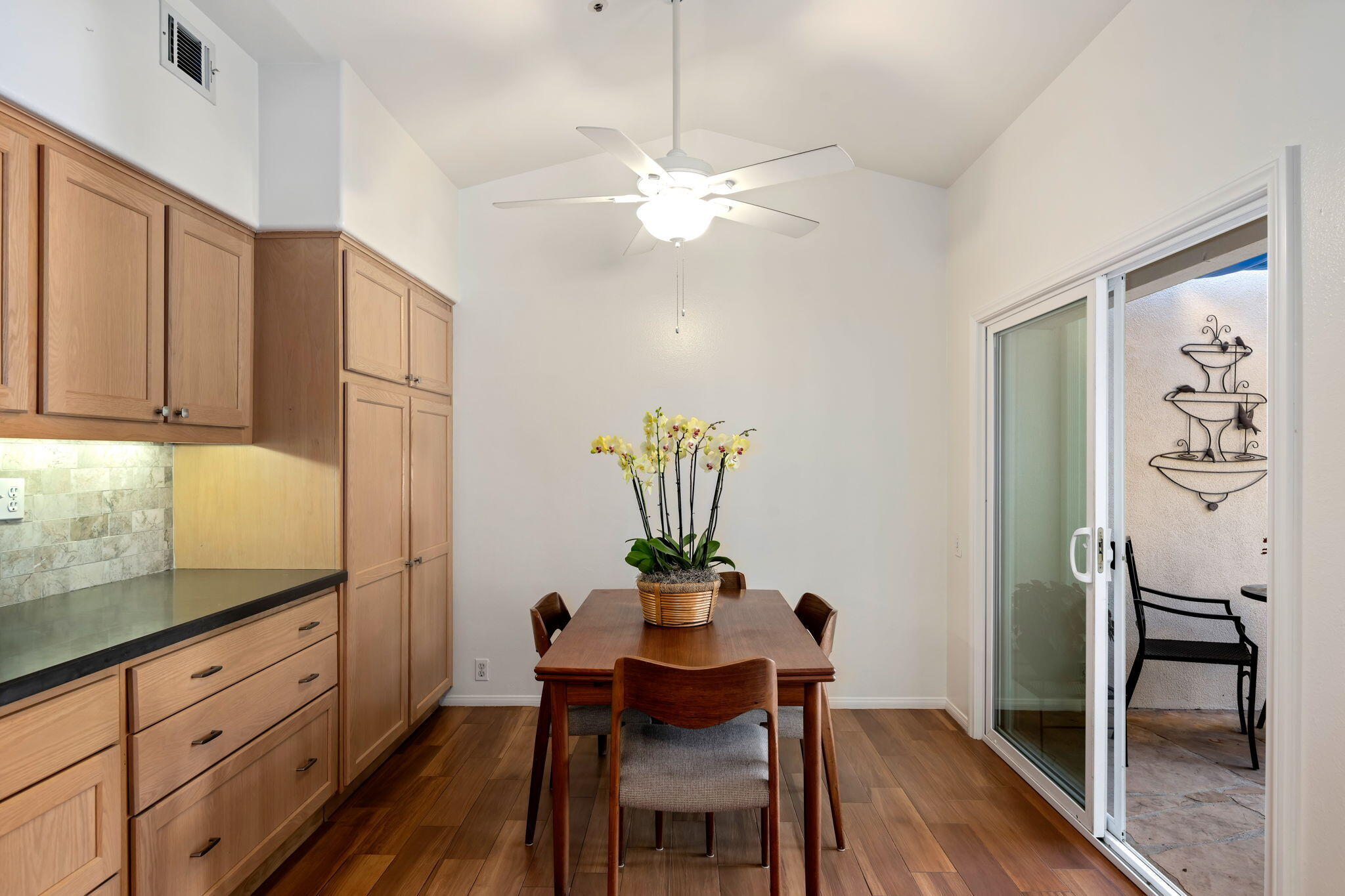 1260 Cravens Lane, Unit 2 Carpinteria, CA 93013 - Photo 9 of 23 a dining room with furniture a chandelier and wooden floor