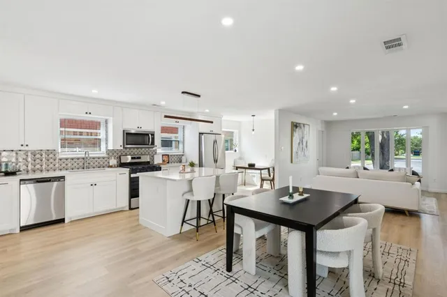 a kitchen with a dining table chairs and view living room