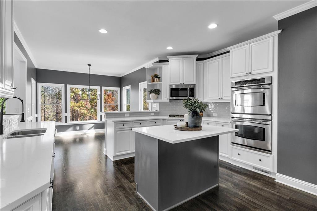 271 Ivy Hall Lane Dallas, GA 30132 - Photo 25 of 120 a kitchen with kitchen island white cabinets and stainless steel appliances