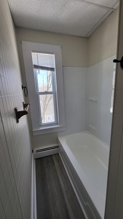 19 Delmont Avenue, Unit 19 Lowell, MA 01852 - Photo 11 of 14 a bathroom with a bathtub and a window