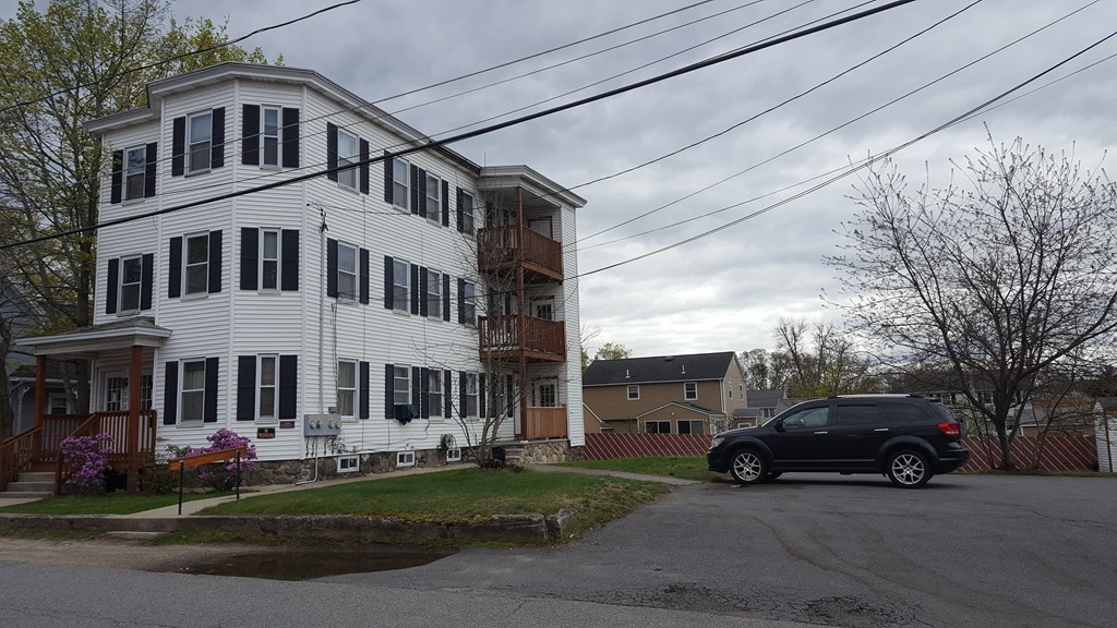 19 Delmont Avenue, Unit 19 Lowell, MA 01852 - Photo 2 of 14 a car parked in front of a white house