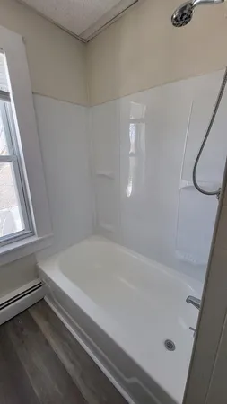 a bathroom with a bathtub and a window