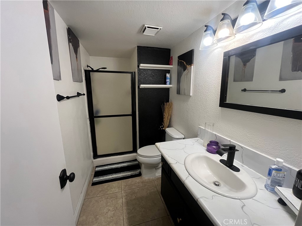 1491 Portrait Street Perris, CA 92571 - Photo 4 of 10 a bathroom with a sink a toilet and mirror