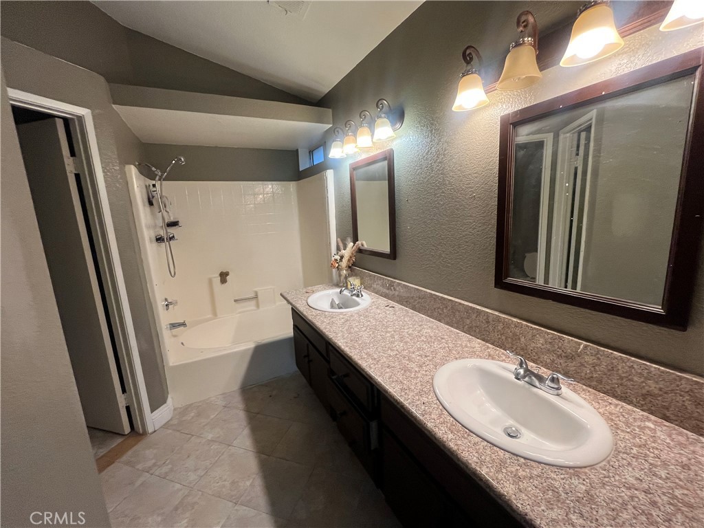 1491 Portrait Street Perris, CA 92571 - Photo 8 of 10 a bathroom with a granite countertop sink and a mirror