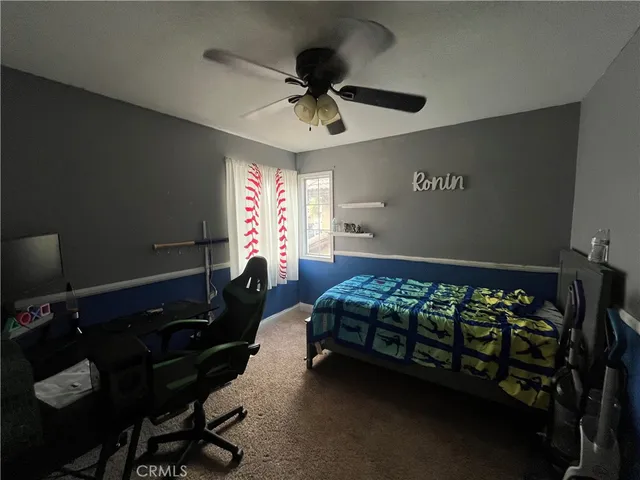 a bed room with a bed window and a ceiling fan