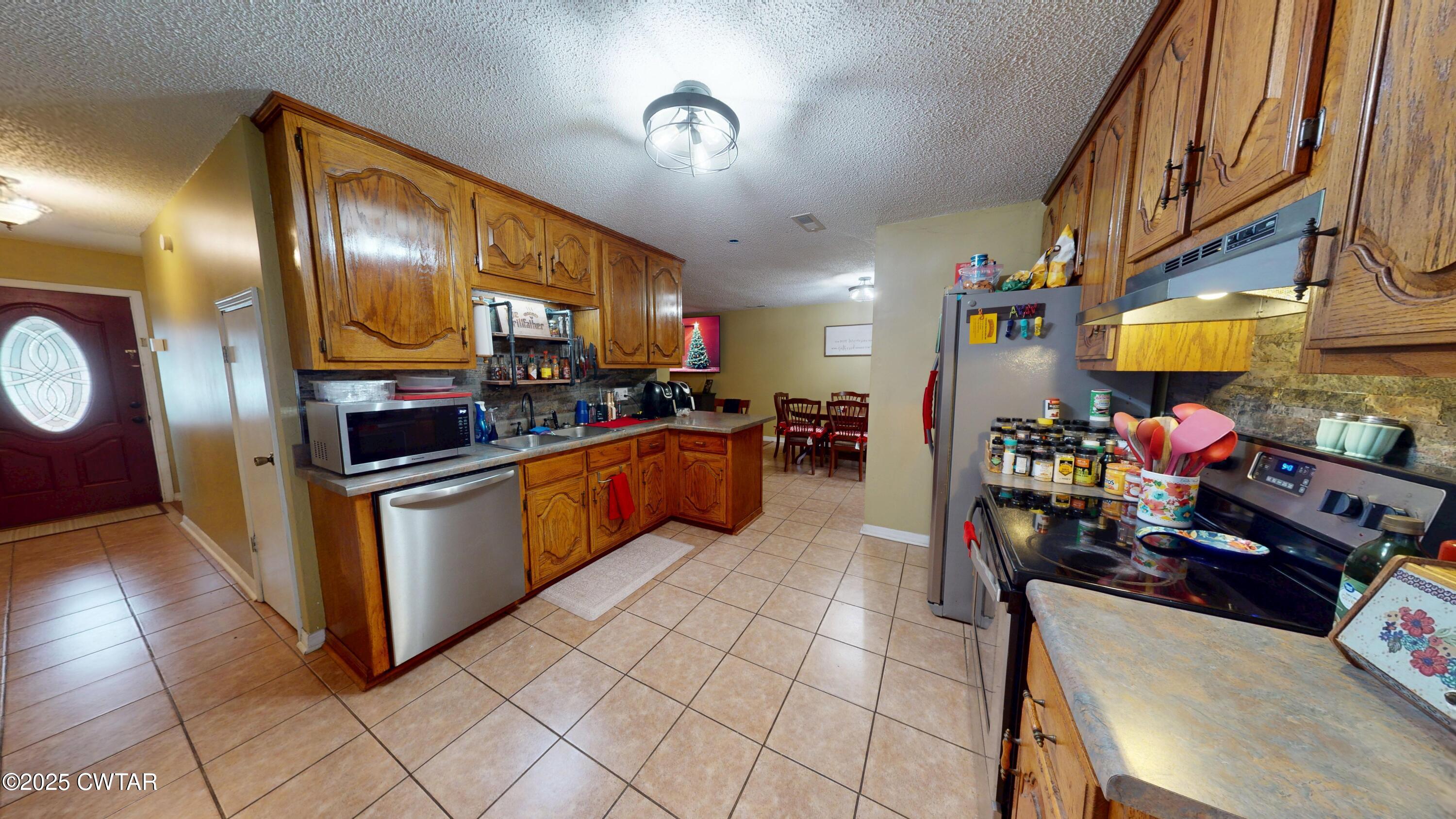625 Hanna Drive Ripley, TN 38063 - Photo 6 of 26 a kitchen with stainless steel appliances granite countertop a stove a sink and a refrigerator