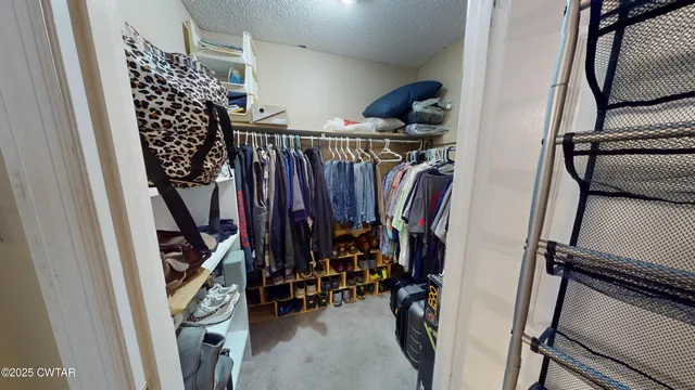 a view of walk in closet with clothes