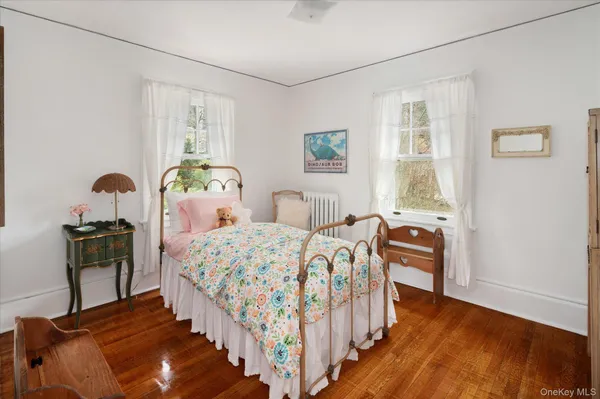 a bedroom with bed and wooden floor
