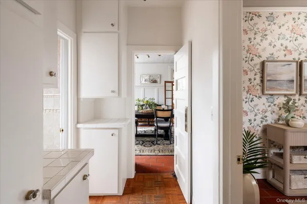 a view of a hallway and a dining room with wooden floor
