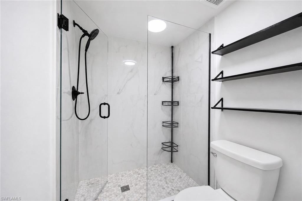 5737 Whitaker Road, Unit C101 Naples, FL 34112 - Photo 13 of 28 a bathroom with a shower toilet and sink