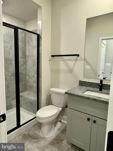 a bathroom with a granite countertop sink toilet and shower