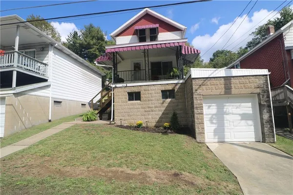 a front view of a house with a garden and garage