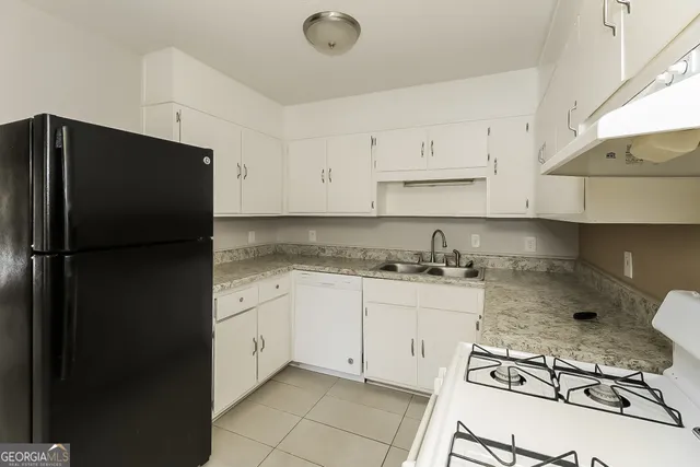 a kitchen with stainless steel appliances granite countertop a refrigerator and a stove