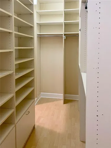 a view of walk in closet with empty racks
