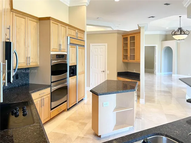 a kitchen with stainless steel appliances granite countertop a stove a sink and a microwave