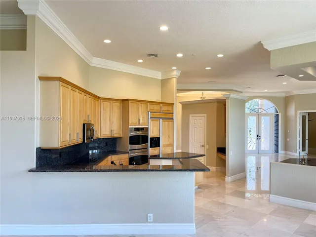 a living room with stainless steel appliances kitchen island granite countertop furniture a sink and a large window