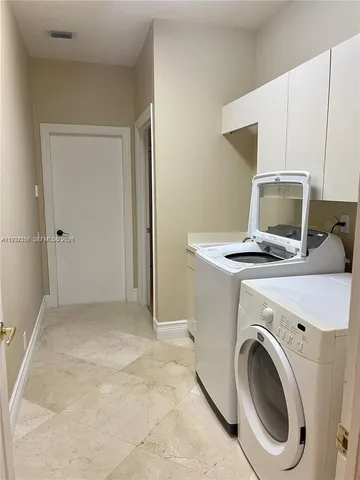 a view of washer and dryer with kitchen in the background
