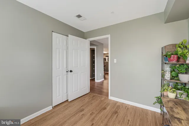a view of a hallway with wooden floor and closet