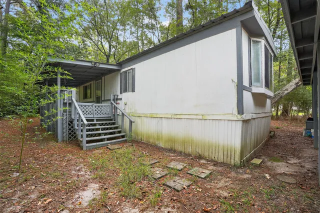 a backyard of a house with wooden floor and outdoor seating