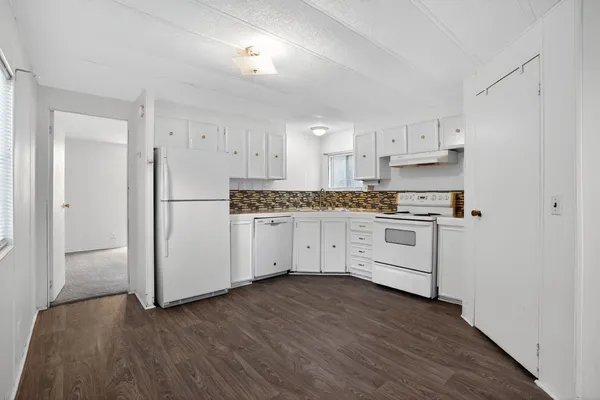 a kitchen with white cabinets and white appliances