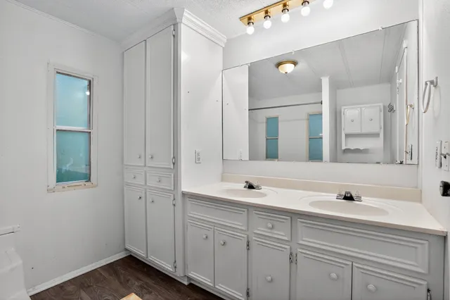 a bathroom with double vanity sink and mirror
