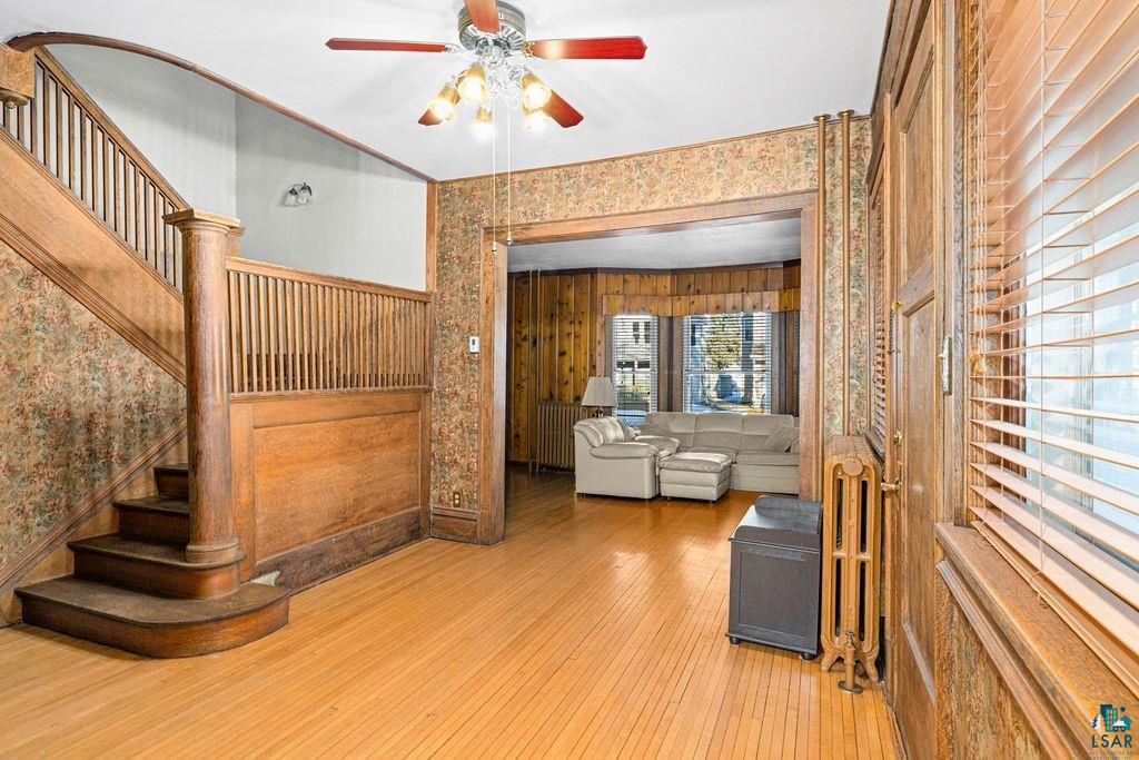 1505 North 19th Street Superior, WI 54880 - Photo 2 of 18 Living room featuring wood-type flooring, radiator heating unit, and a ceiling fan