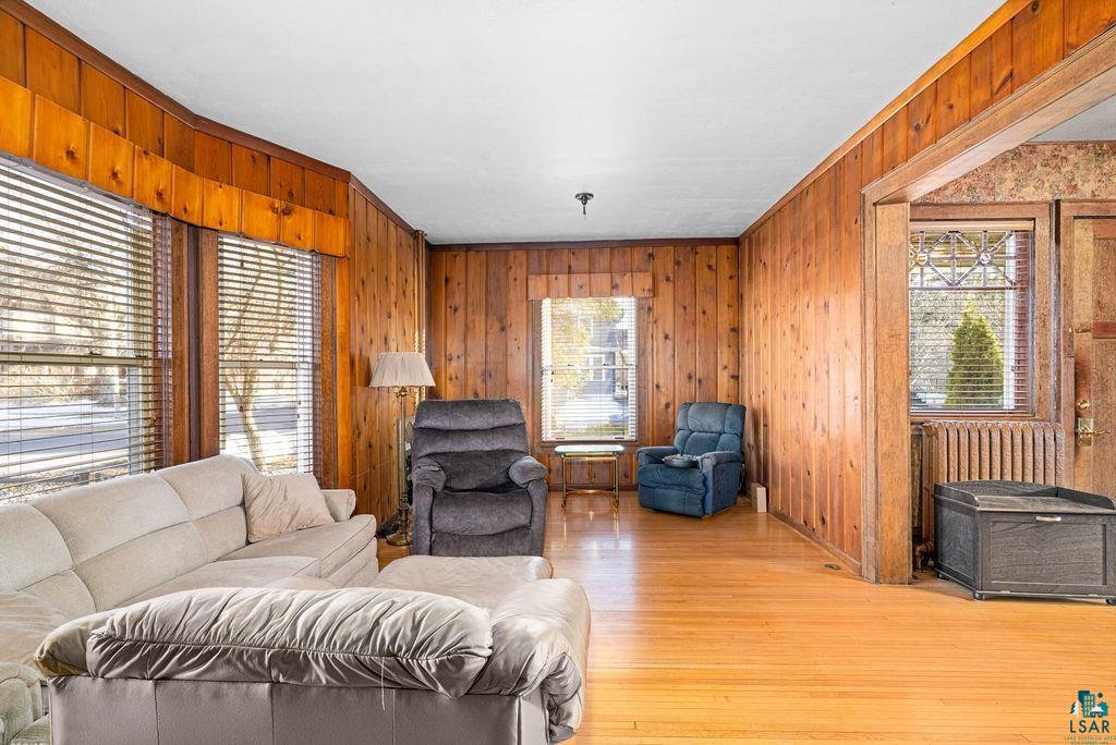 1505 North 19th Street Superior, WI 54880 - Photo 3 of 18 Living room featuring wooden walls, wood finished floors, and ornamental molding