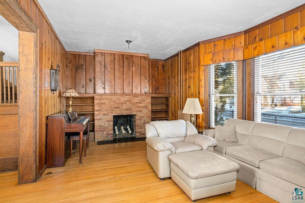 1505 North 19th Street Superior, WI 54880 - Photo 4 of 18 Living area with wooden walls, a fireplace, light wood-style floors, and crown molding