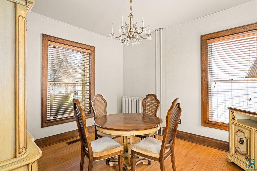1505 North 19th Street Superior, WI 54880 - Photo 6 of 18 Dining space featuring light wood-style flooring, suspended lighting, and radiator heating unit
