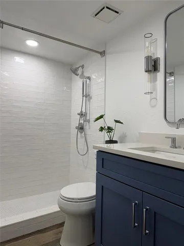 a bathroom with a sink a toilet and shower