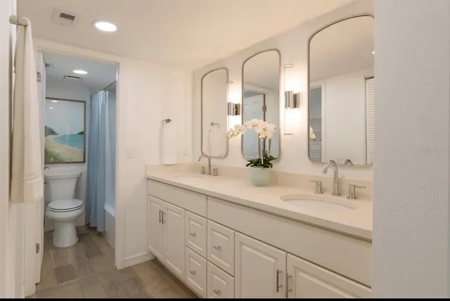 a bathroom with a double vanity sink and a toilet
