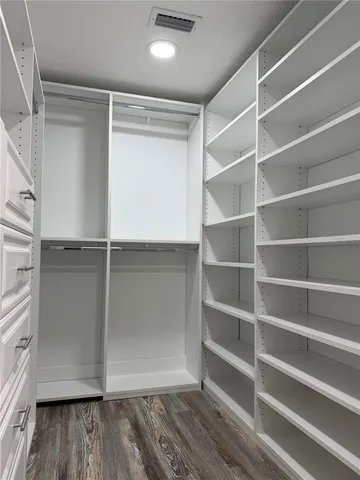 a view of walk in closet with empty racks