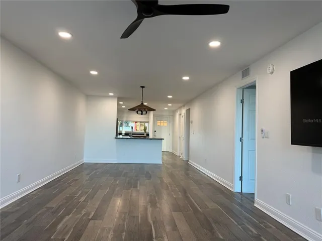 a view of empty room with wooden floor
