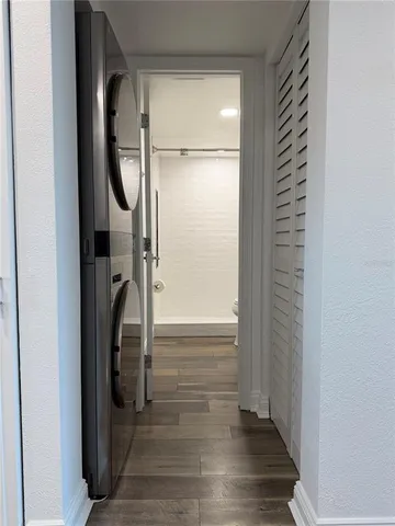 a view of a hallway with wooden floor and a bathroom