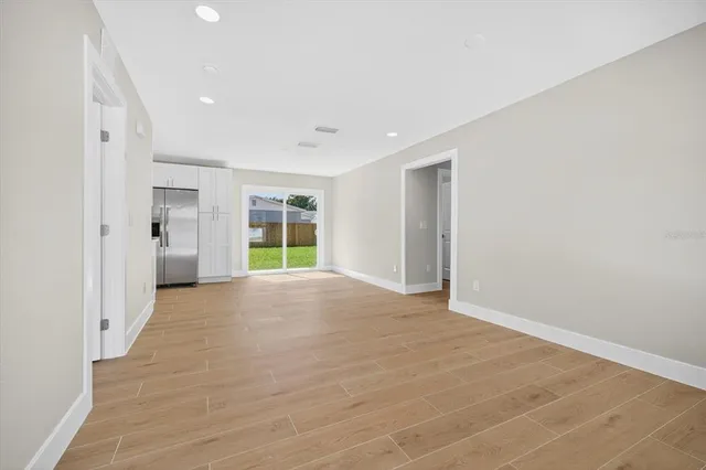 a view of an empty room with closet and a window