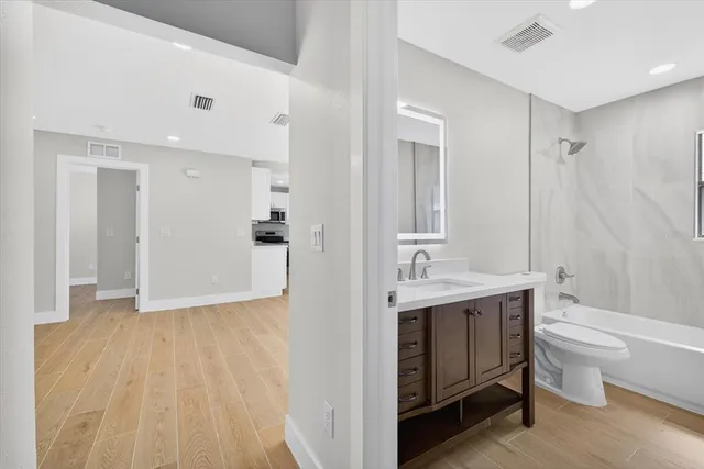 a view of an empty room with wooden floor
