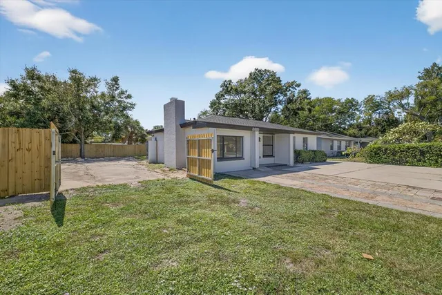 a view of a house with a yard and potted plants