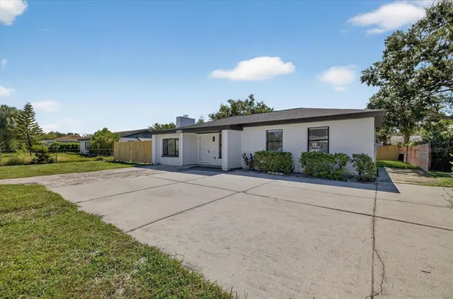 a view of a house with backyard and trees