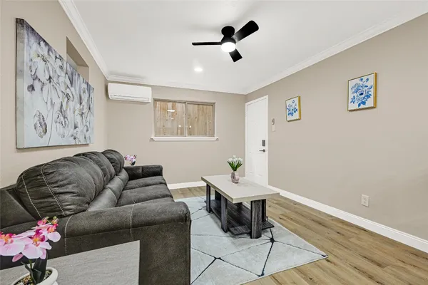 a living room with furniture and a wooden floor
