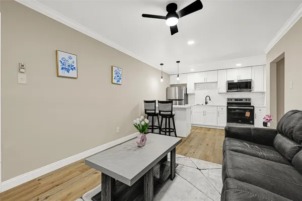 a living room with stainless steel appliances kitchen island furniture and a view of kitchen